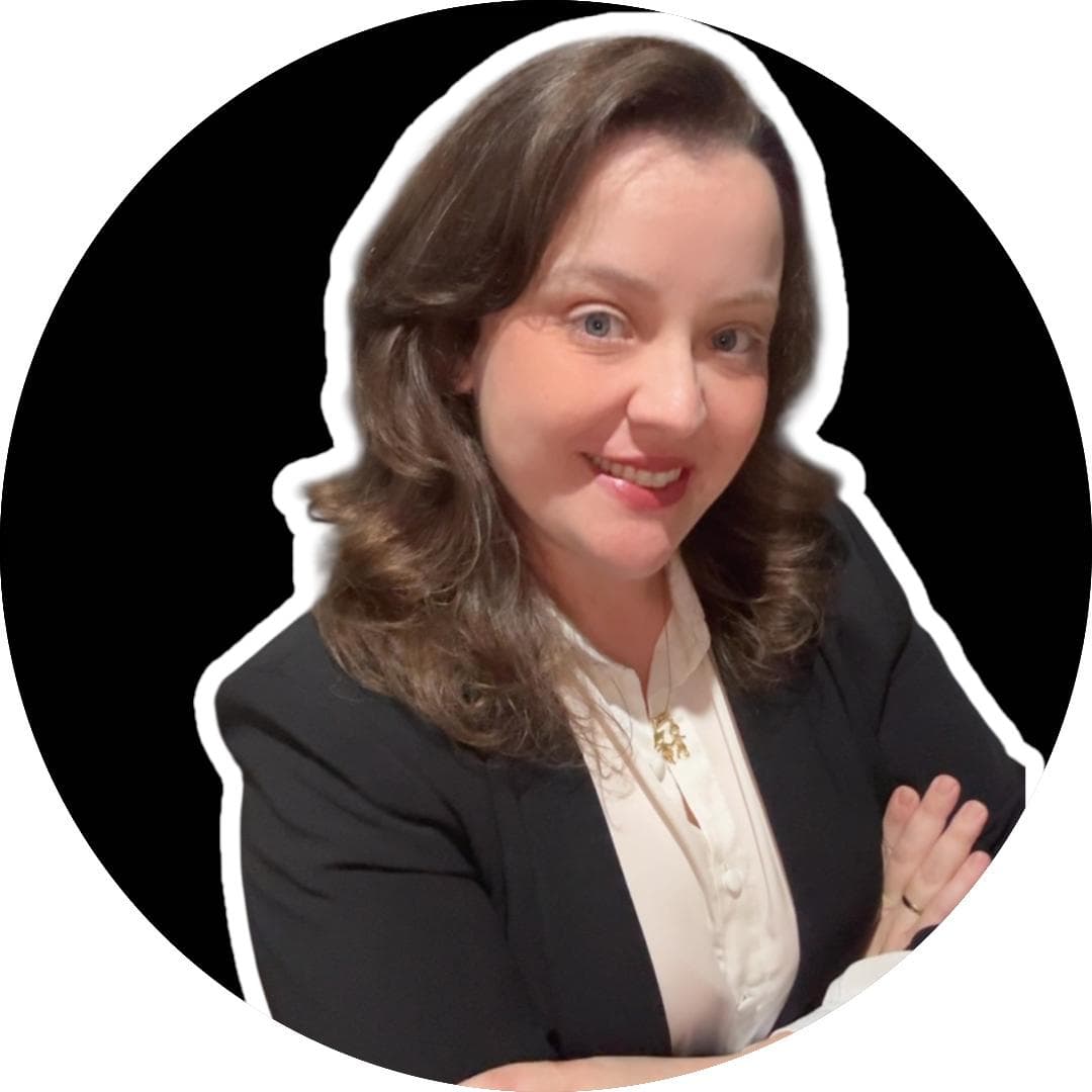 Mulher sorridente de cabelos castanhos ondulados, vestindo blazer preto e blusa branca em fundo circular.